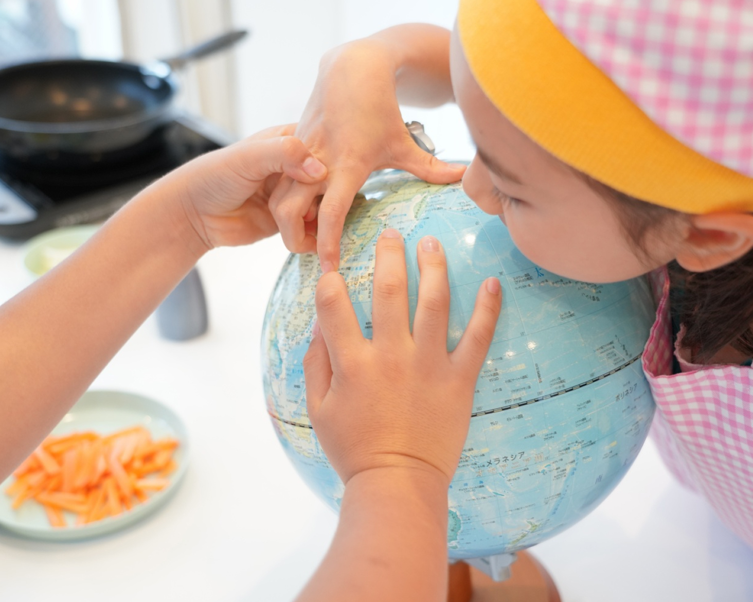 子どもたちが世界地図を指さすイメージ