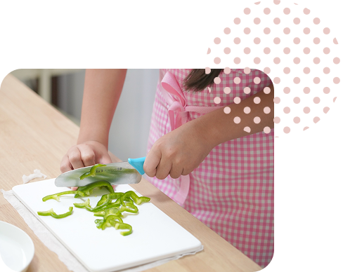 女の子が野菜を切る様子