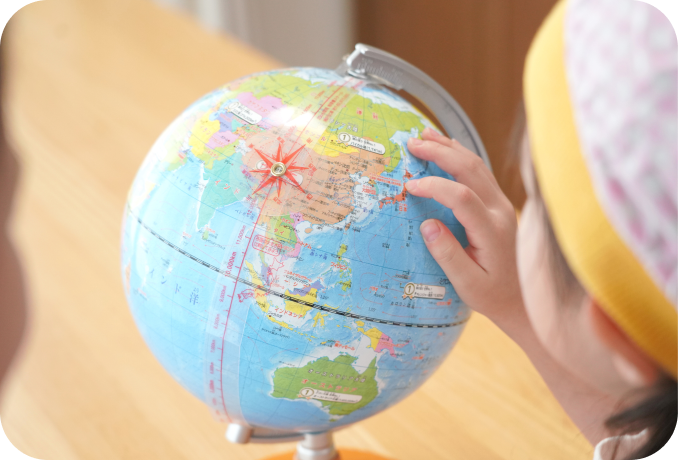 世界地図を指さすこども